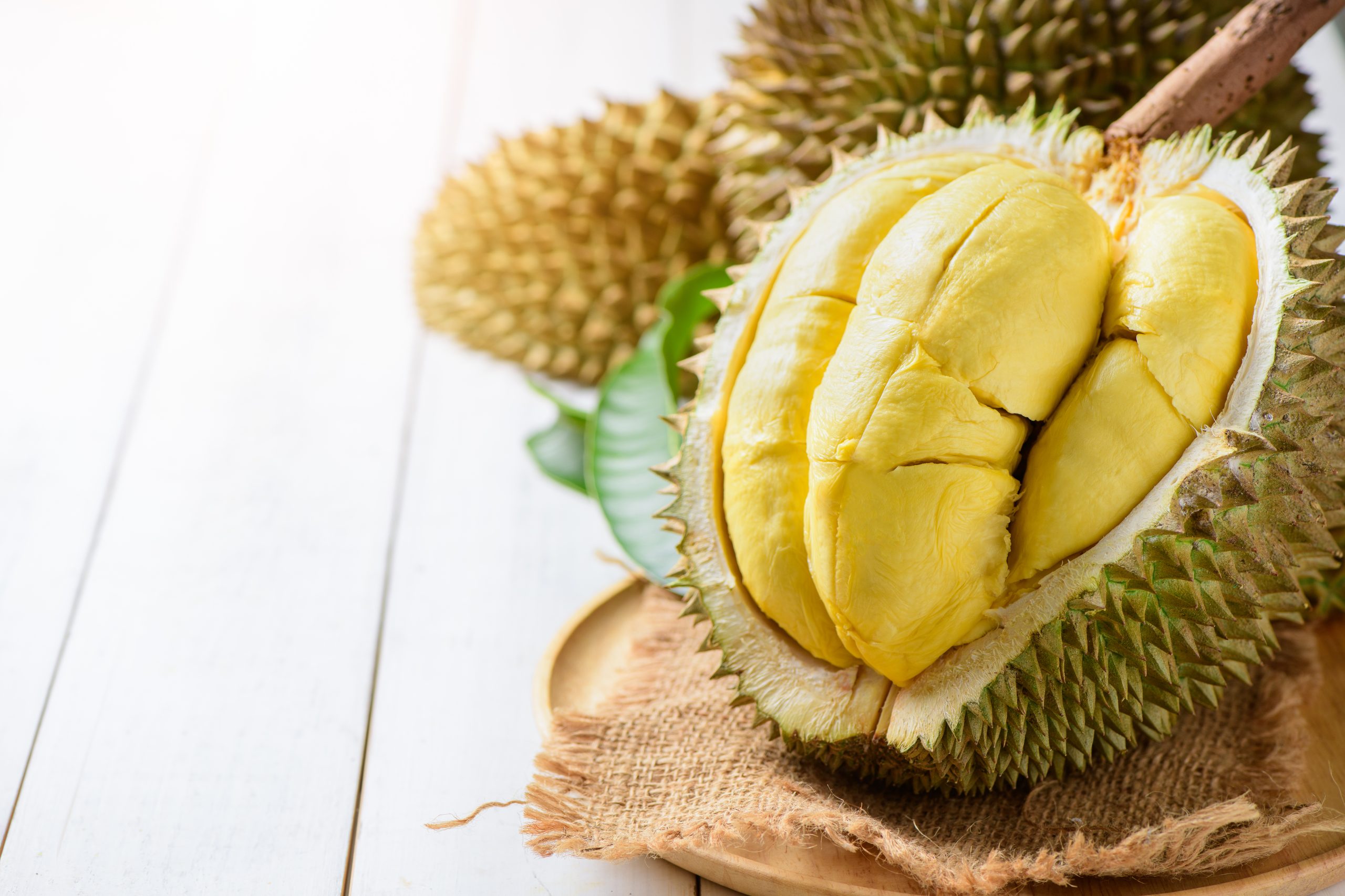 Fresh durian (Kan yao) or Durio zibthinus Murray on sack and old wood background, king of fruit from Thailand on summer season